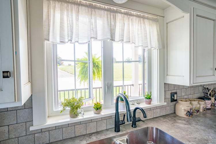 Two white ProVia Endure casement windows with crank handles above a kitchen sink