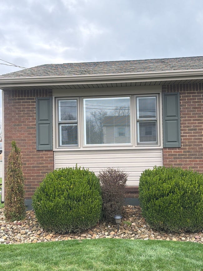 Large center picture window flanked by two double-hung windows on a brick home