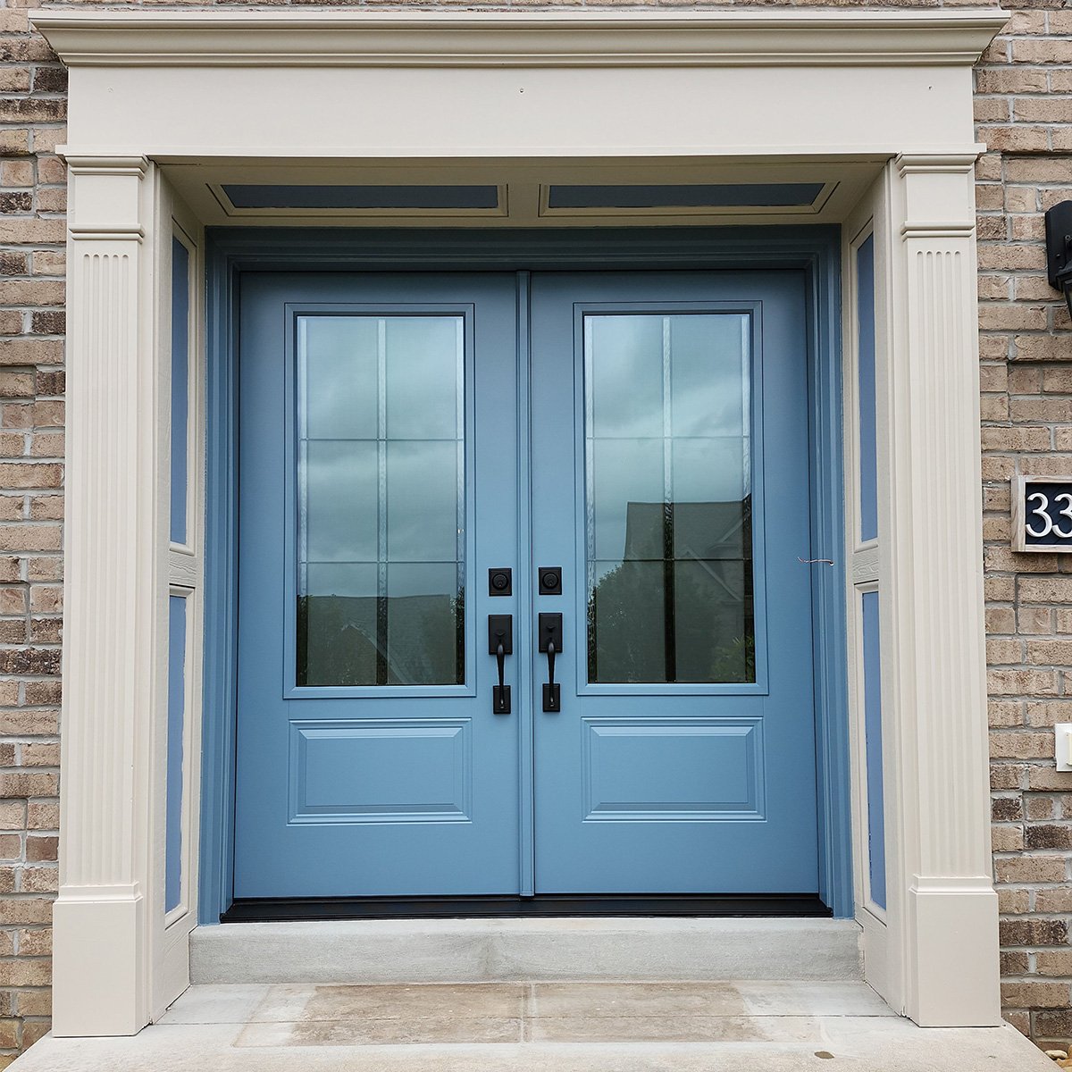Blue double entry door in steel with decorative glass panels