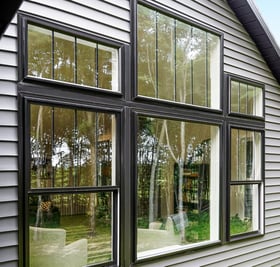 Large black double-hung and picture windows with black grids.