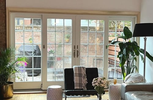 Photo of white sliding patio doors with grids taken from inside a living room.