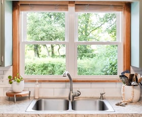 Two white double-hung windows over a kitchen sink.