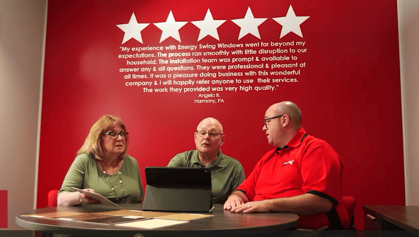 Sales consultant sitting with a mature couple looking at an iPad.
