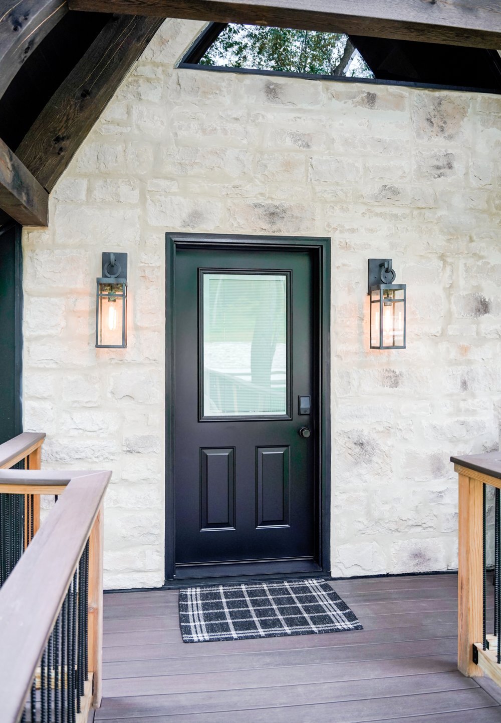 Black half-glass ProVia steel entry door on a stone home