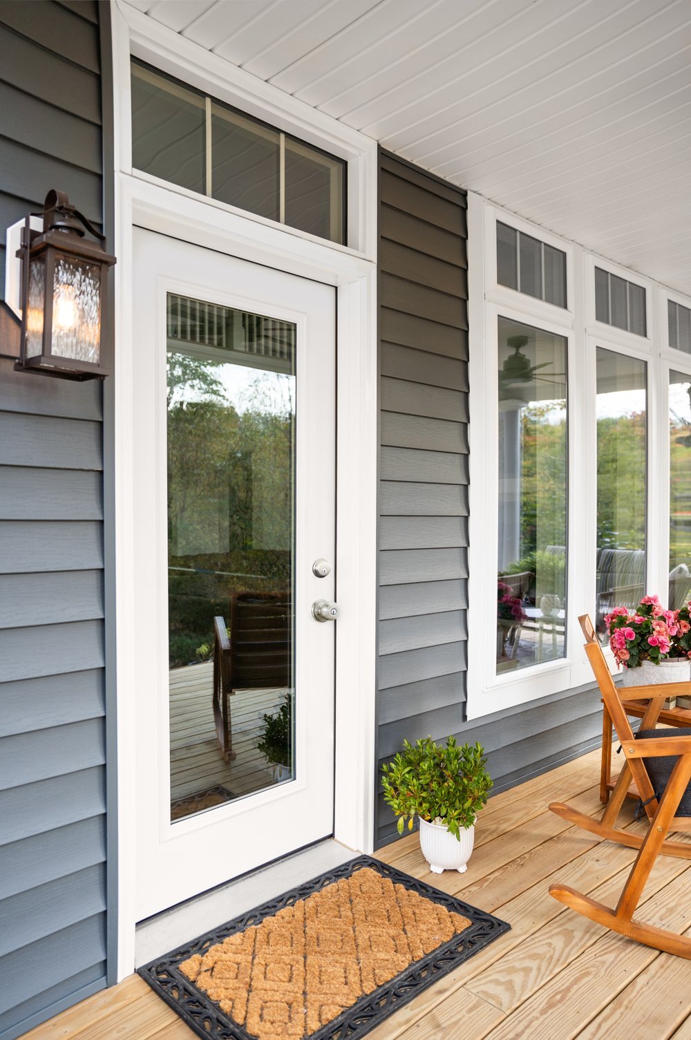 White full-glass ProVia steel door with a transom on a covered porch