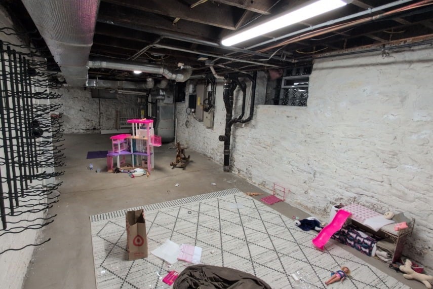 Unfinished basement with exposed concrete and utilities before basement finishing