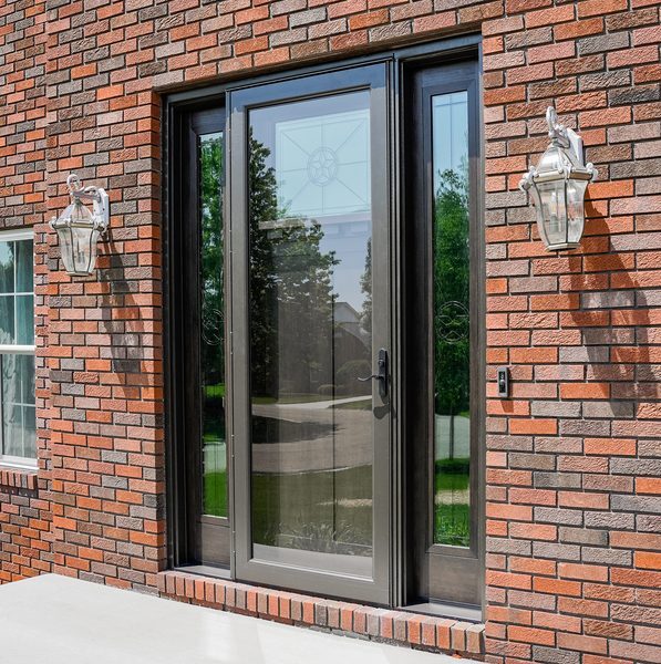 Black-framed glass patio door on a brick home