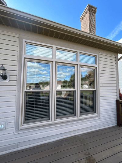 three side by side tan double hung windows