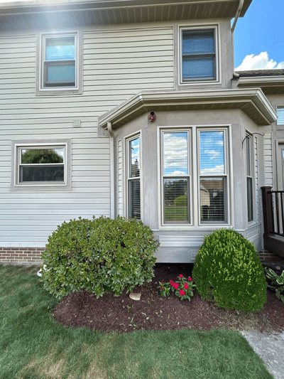 Back of tan home with new windows