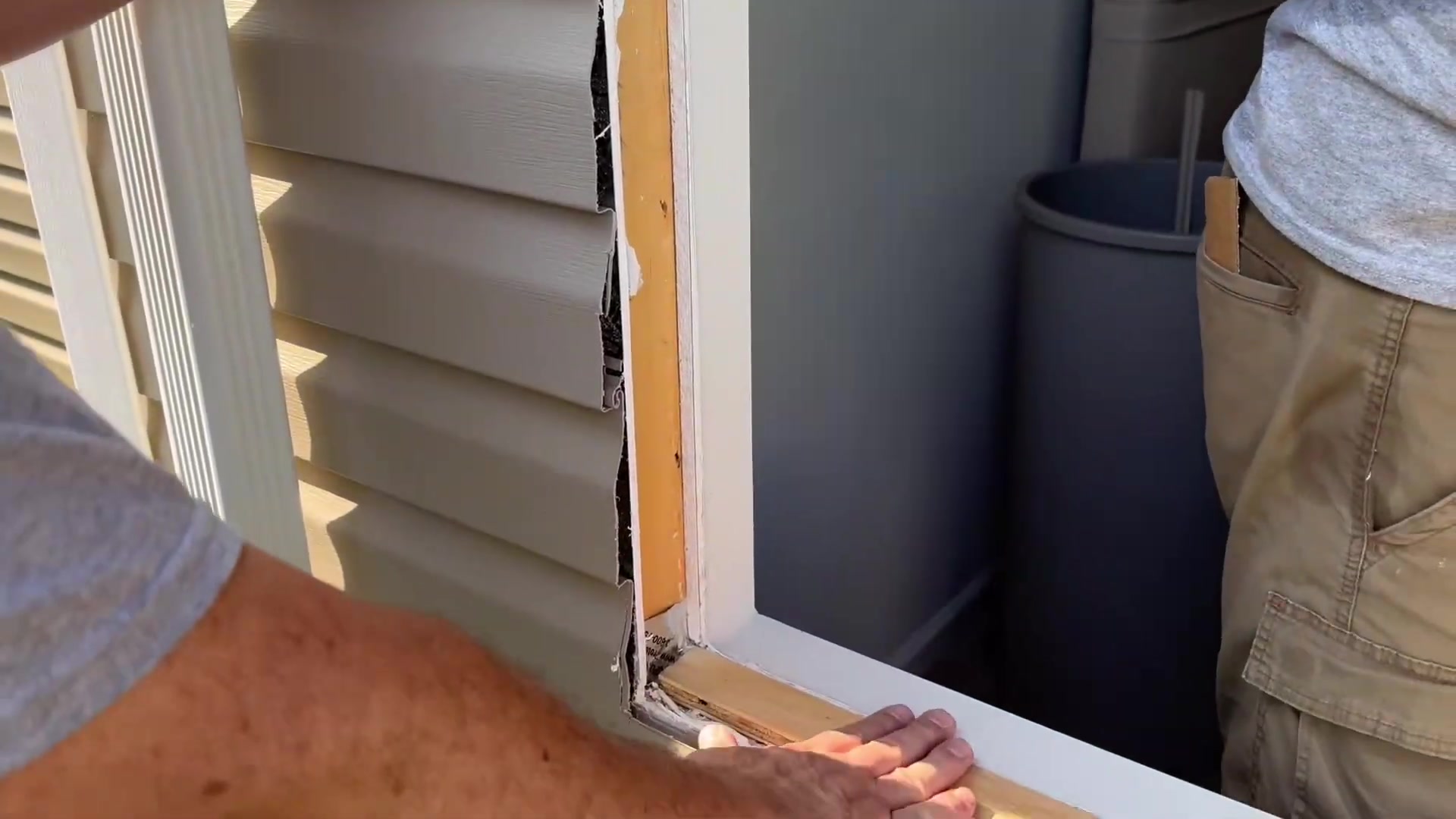 Old window opening with pulled-back siding showing where water can get in
