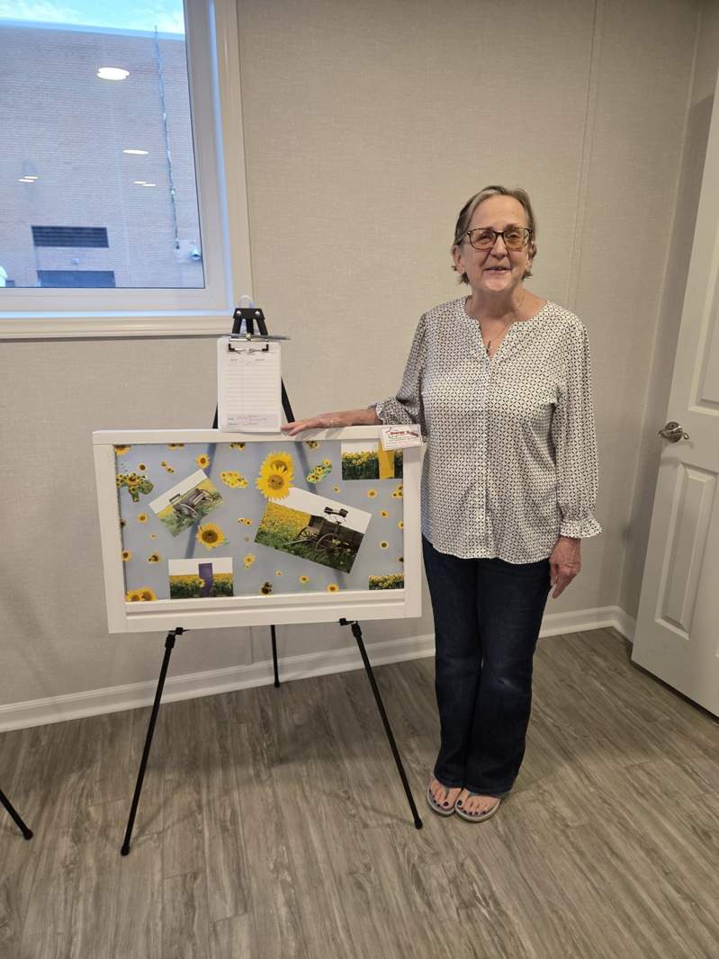 Community member with sunflower-inspired window art at the October 1, 2026 Design Center event
