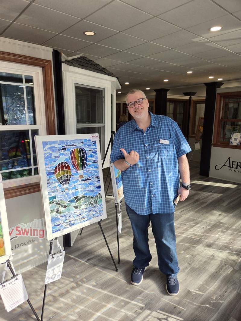 Community member with hot-air-balloon artwork at the October 1 Design Center event