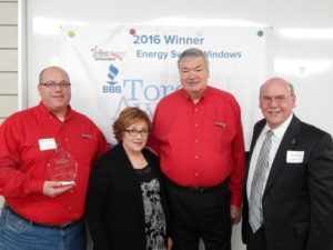 four people in red and black shirts win an award