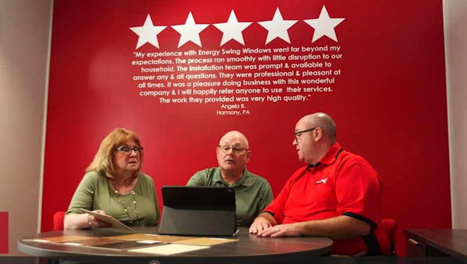 Energy Swing sales consultant sitting with mature couple looking at Ipad.